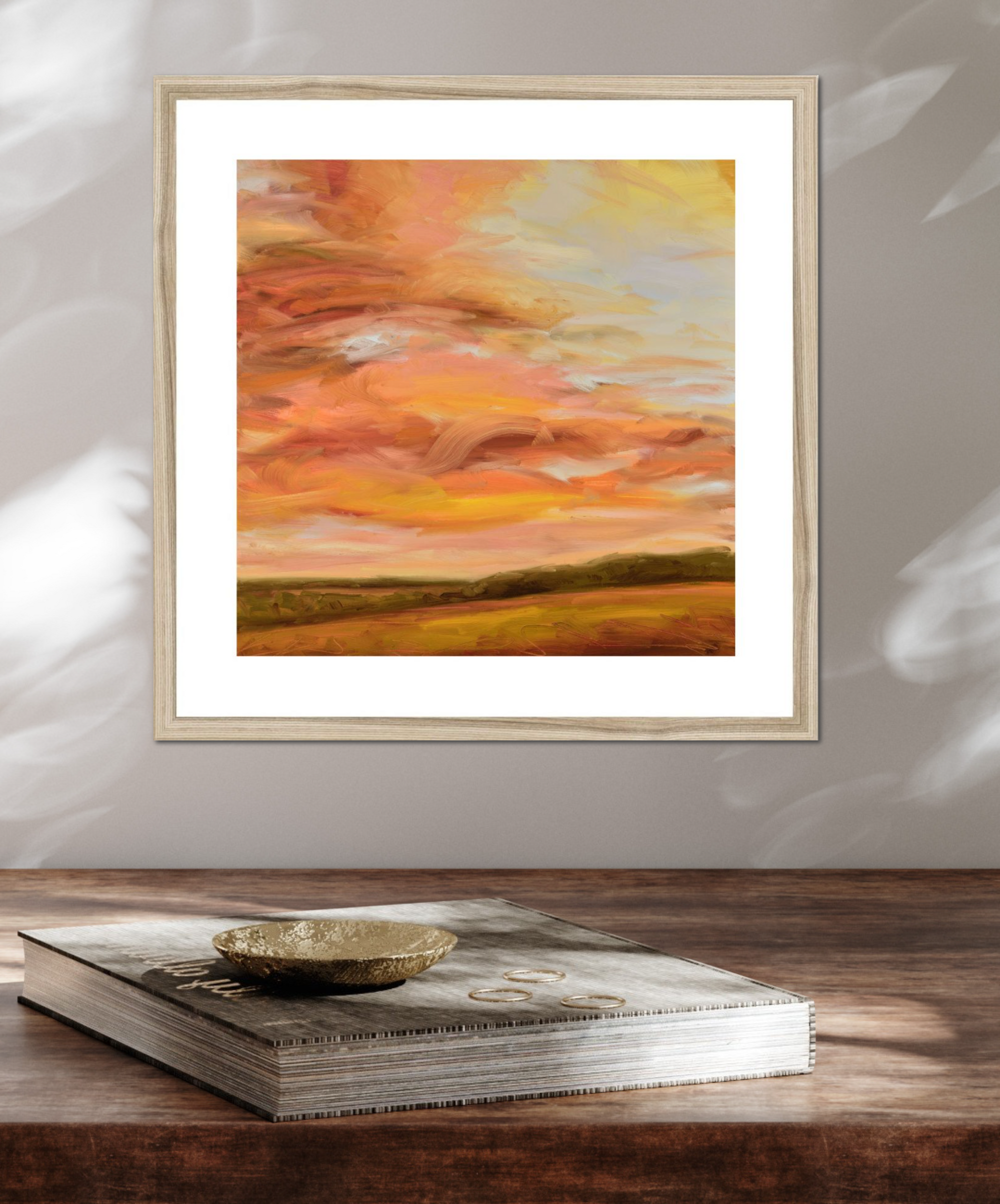 Framed abstract painting with warm colors on a wooden surface