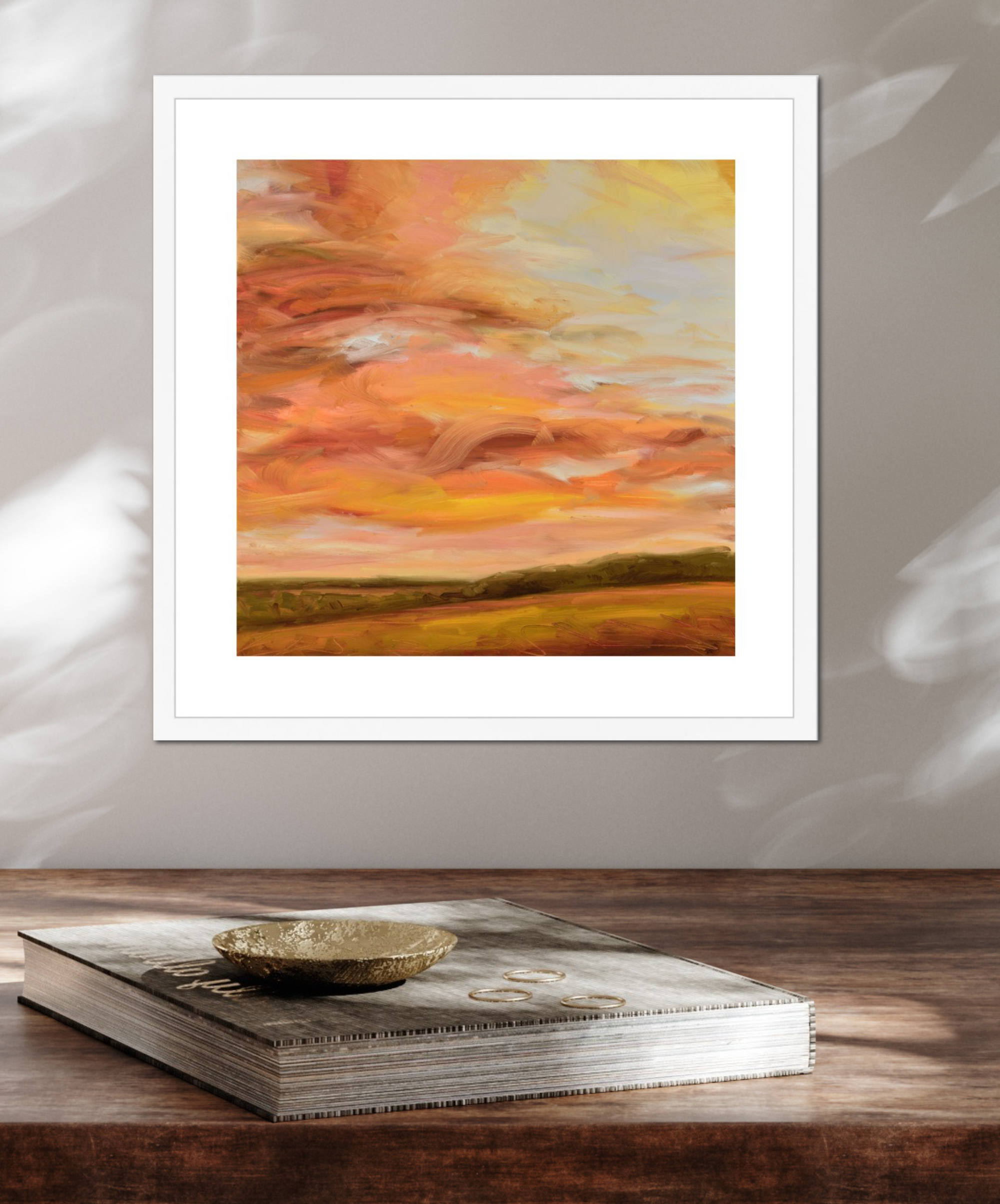 Framed abstract painting with warm colors on a wooden surface