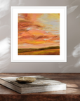 Framed abstract painting with warm colors on a wooden surface