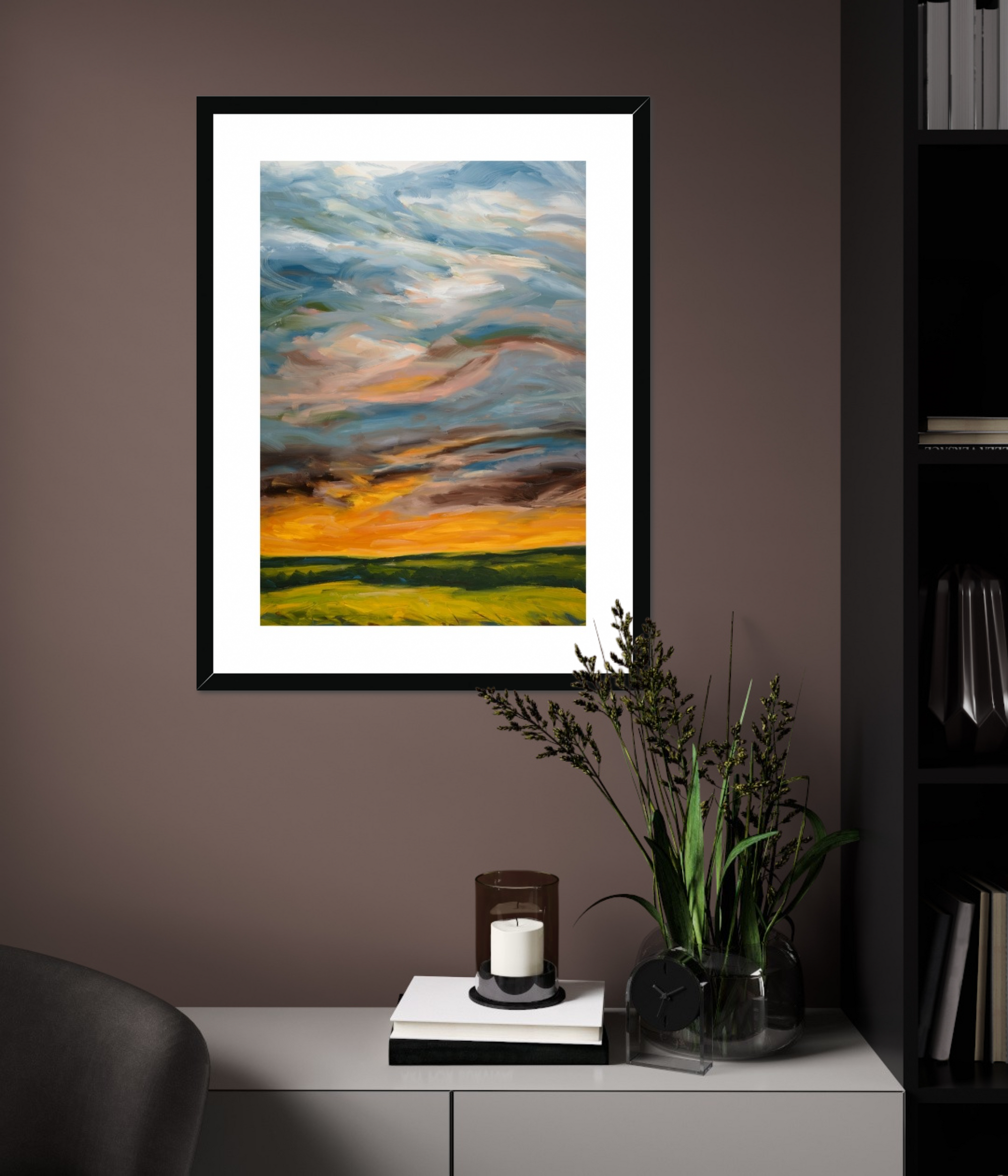 Framed abstract landscape painting on a wall with a candle and plant below.