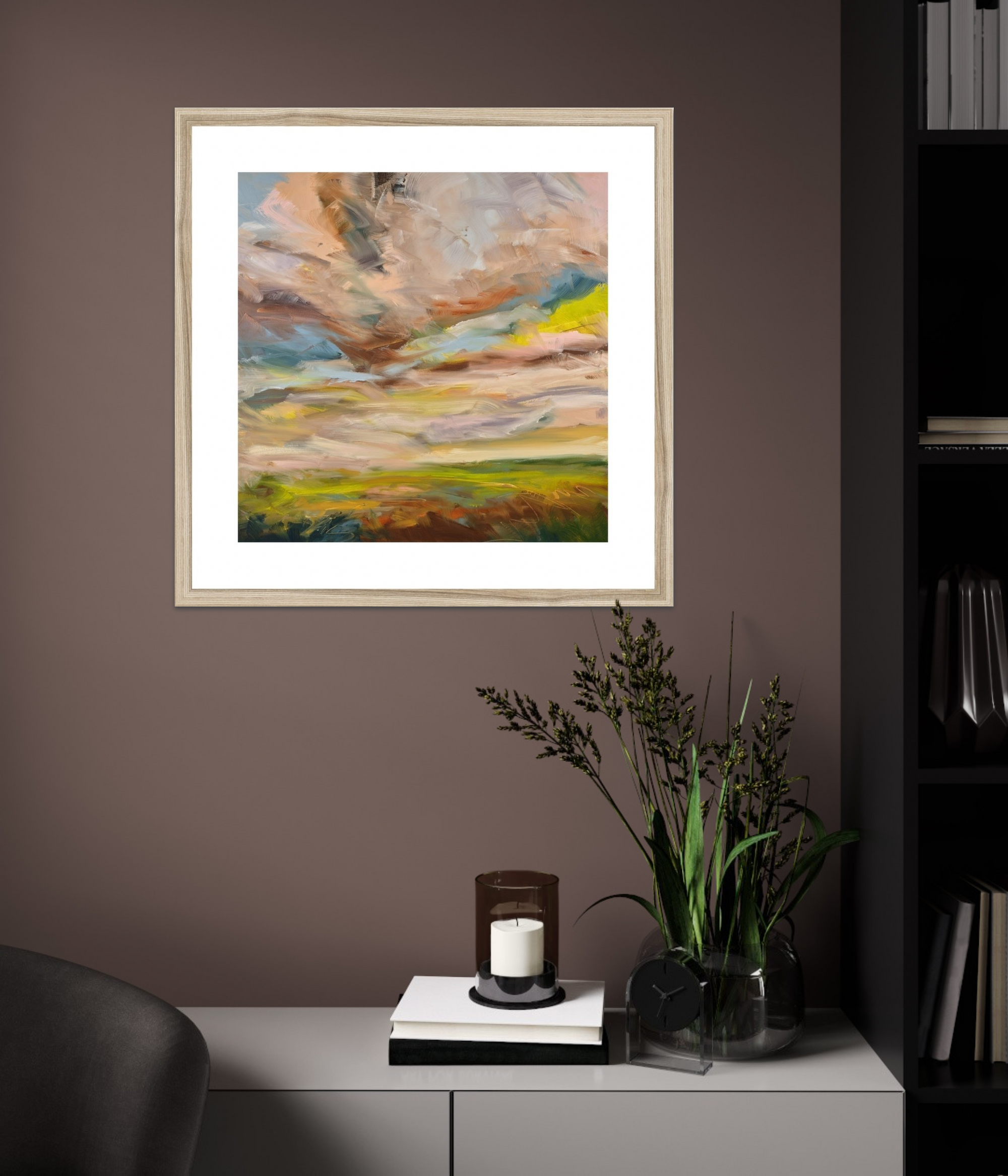 Framed abstract painting on a wall with a candle and plant on a table below.