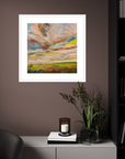 Framed abstract painting on a wall above a cabinet with decorative items.