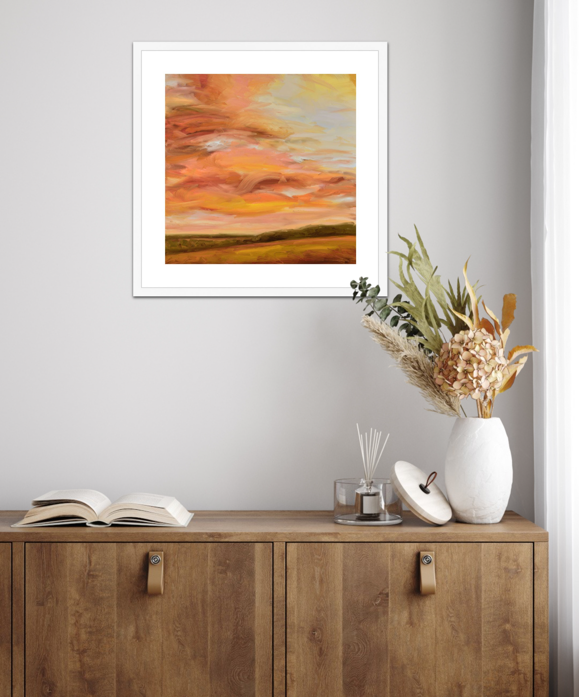 Framed abstract painting on a wall above a wooden cabinet with decorative items.