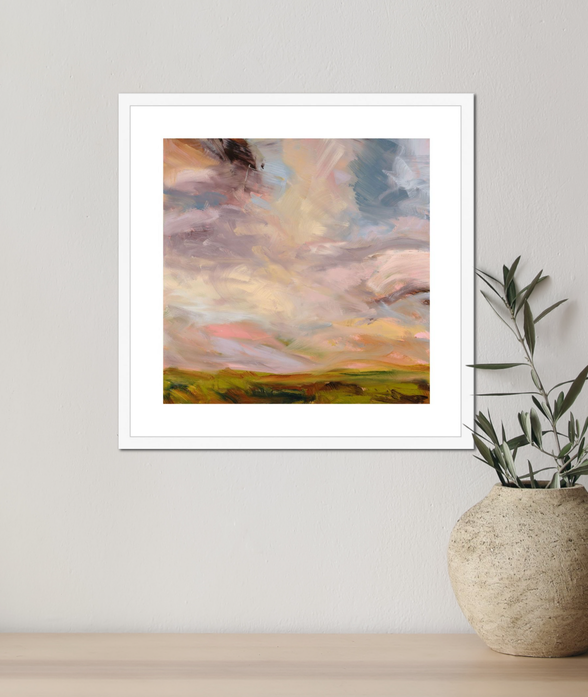 Framed abstract painting on a wall with a plant below