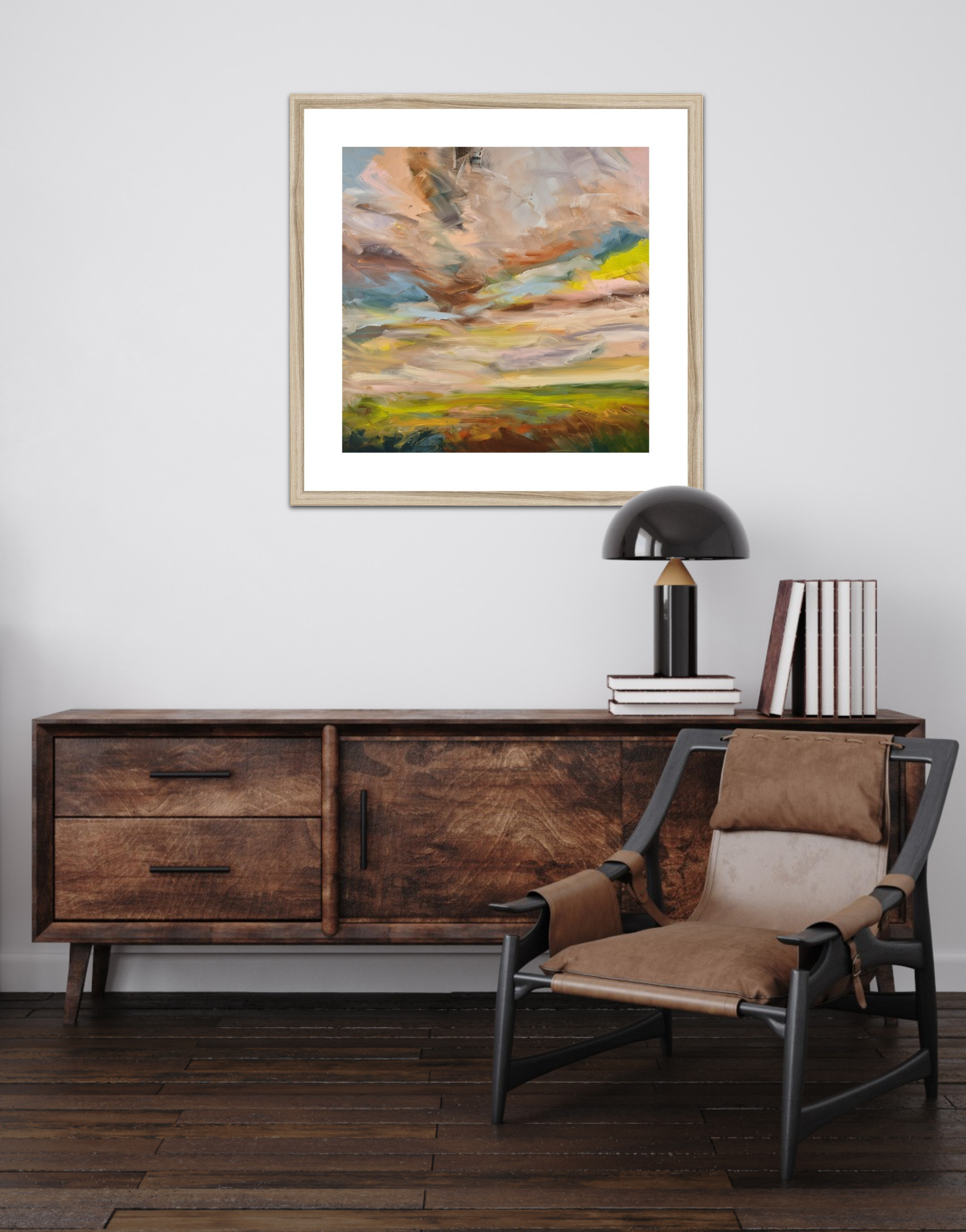 Wooden sideboard with a chair, books, and a lamp in a room with a framed abstract painting on the wall.
