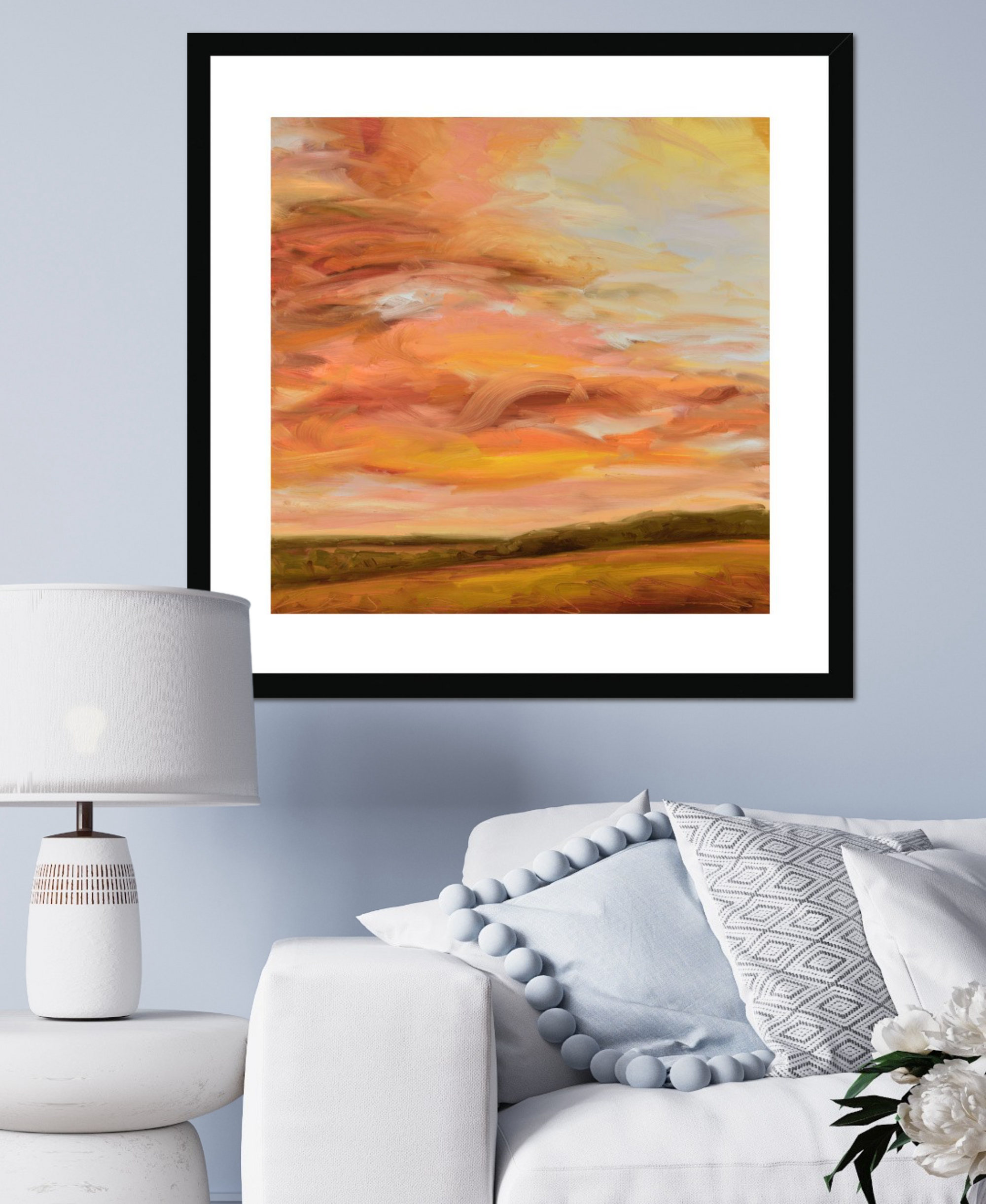 Framed abstract painting of a sunset over a field in a living room setting.