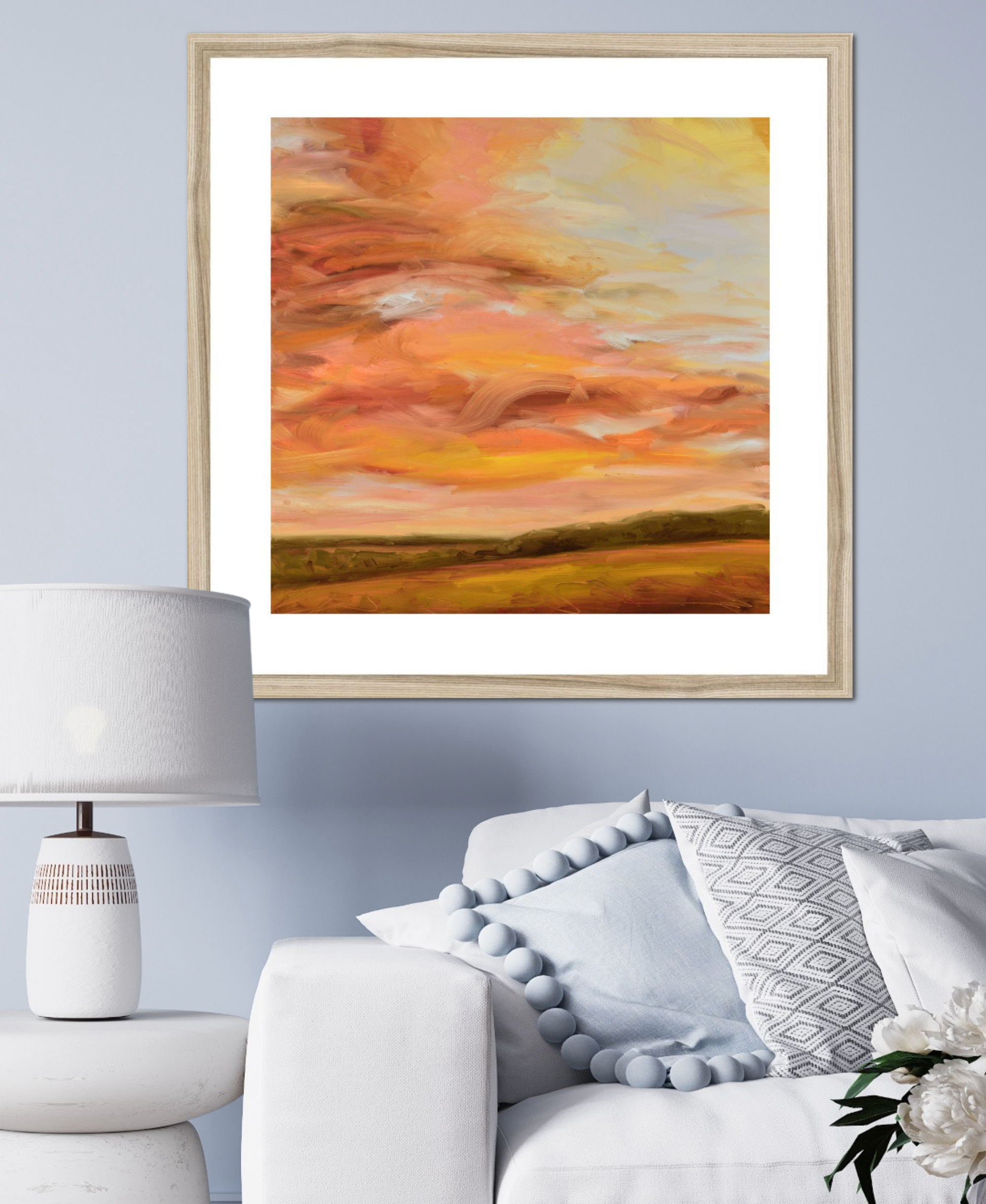 Framed abstract painting of a sunset over a field in a living room setting.