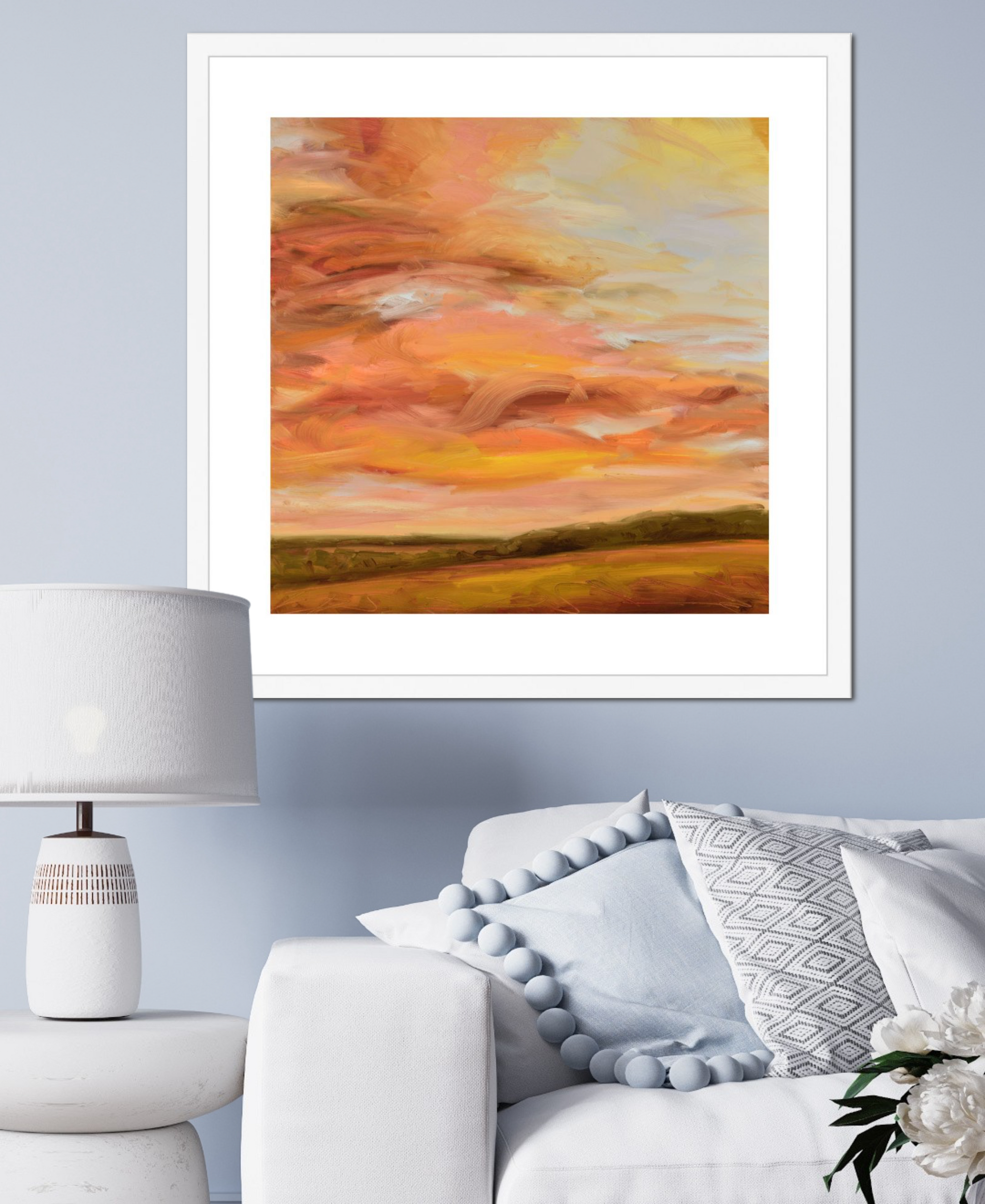 Framed abstract painting of a sunset over a field in a living room setting.