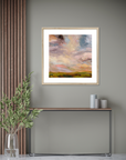 Framed abstract painting on a wall with a console table and decorative items below.
