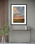 Framed artwork of a sunset over a field in a modern interior setting.