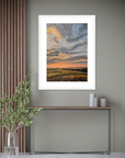 Framed artwork of a sunset over a field in a modern interior setting.