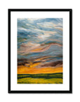 Framed abstract painting of a landscape with colorful skies and green fields.