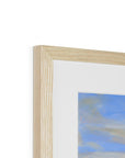 Close-up of a wooden picture frame with a blurred artwork inside on a white background