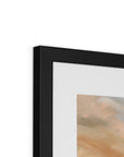 Close-up of a black framed artwork with a white mat on a white background