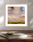 Framed abstract painting on a wooden surface with a book underneath