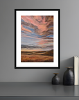 Framed abstract artwork on a gray wall with decorative items below.