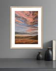 Framed abstract artwork on a gray wall with decorative items below.