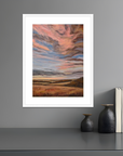 Framed abstract artwork on a gray wall with decorative items below.