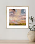 Framed abstract artwork on a wall next to a vase with plants