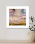 Framed abstract painting on a wall with a plant below