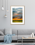 Framed abstract painting in a living room setting with a gray sofa and coffee table.