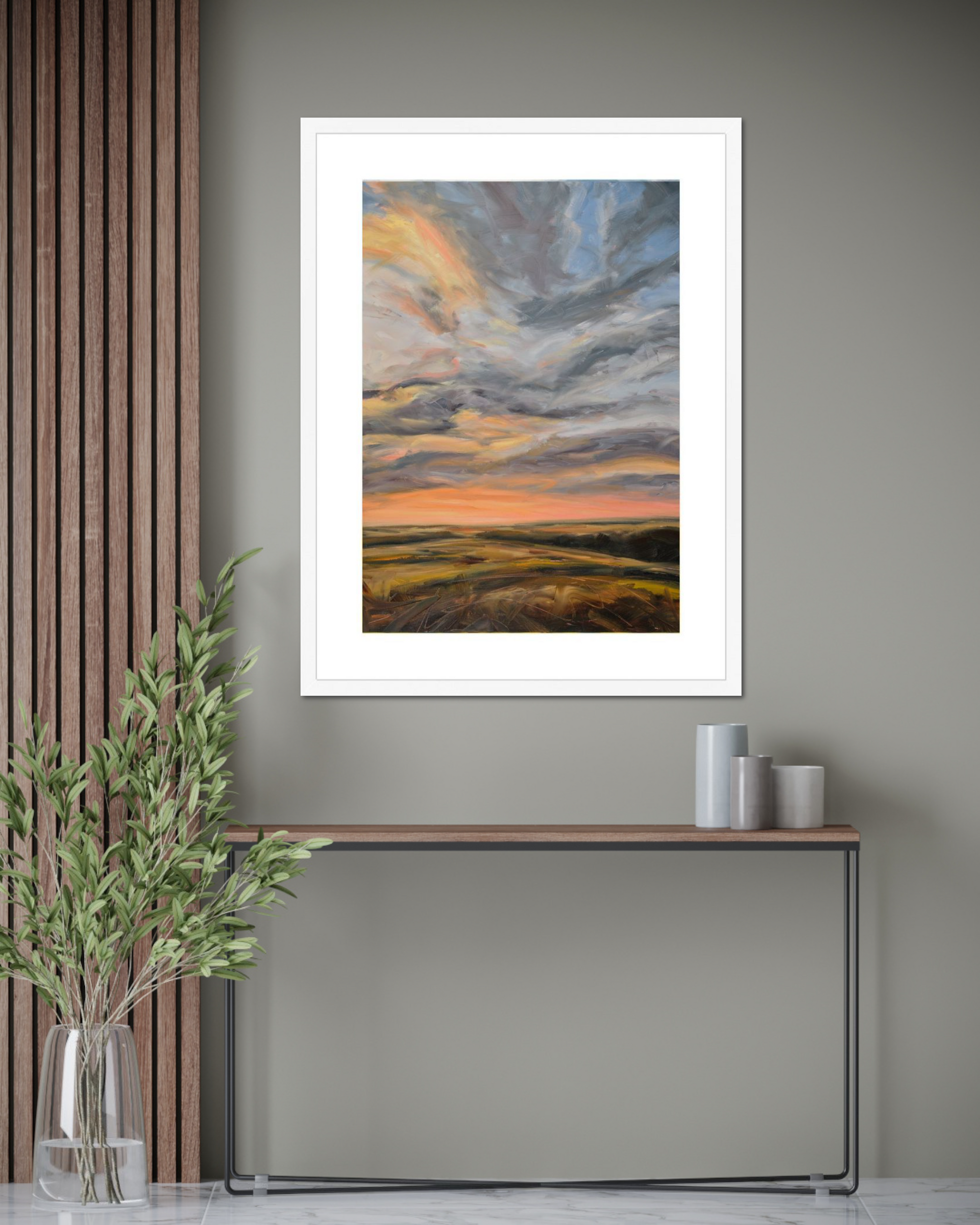 Framed artwork of a sunset over a field in a modern interior setting.