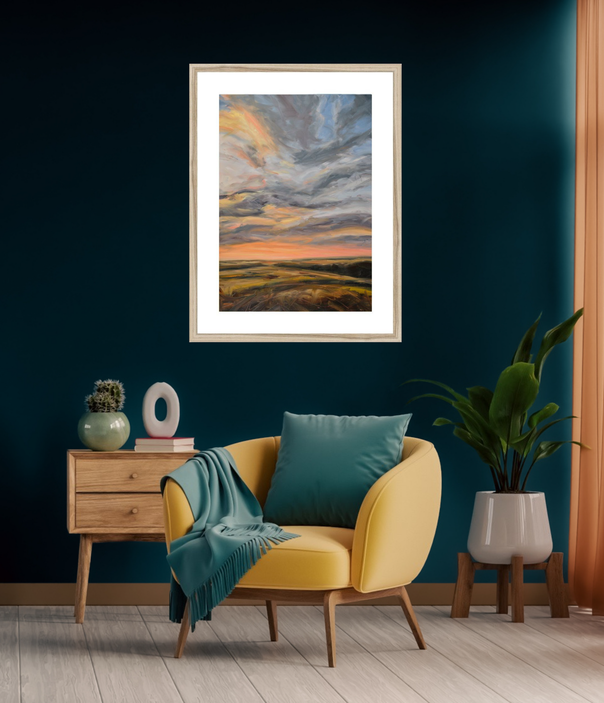 Yellow armchair with teal cushions and a green blanket in a room with a framed landscape painting on the wall.