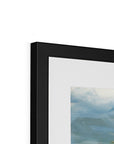 Close-up of a black framed abstract painting with a white background