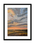 Framed abstract painting of a sunset with warm colors on a white background